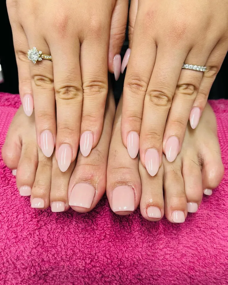 Soft nude almond nails with matching nude toes on a pink towel