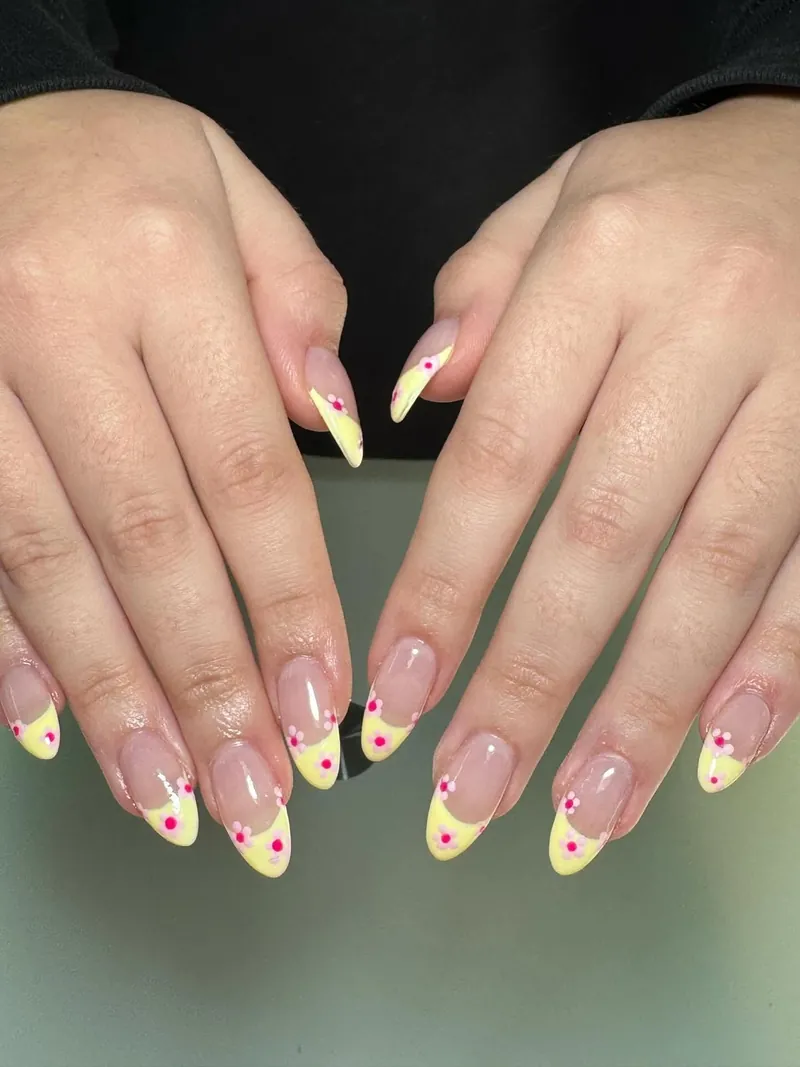 Almond nails with lemon yellow tips and small pink hearts